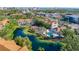 Picturesque aerial view showcasing the community's pool, tennis court, and tranquil pond, surrounded by lush greenery at 850 S Tamiami Trl # 207, Sarasota, FL 34236