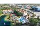 An aerial view of the community featuring a pool, tennis court, picturesque pond, and well-maintained landscaping at 850 S Tamiami Trl # 207, Sarasota, FL 34236
