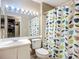 Bathroom with vanity, toilet, and shower with leaf-patterned curtain under bright lighting at 850 S Tamiami Trl # 207, Sarasota, FL 34236