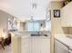 Bright kitchen area with white cabinets, sink, and a view into the living space at 850 S Tamiami Trl # 207, Sarasota, FL 34236