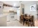 Bright kitchen with white cabinetry and appliances. The space includes a dining table and artwork at 850 S Tamiami Trl # 207, Sarasota, FL 34236
