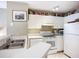 Bright kitchen with white cabinetry, appliances, and a double basin sink under an art piece at 850 S Tamiami Trl # 207, Sarasota, FL 34236