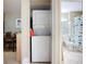 Hallway laundry closet featuring a stacked washer and dryer with bathroom in view at 850 S Tamiami Trl # 207, Sarasota, FL 34236