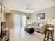 A cozy living room featuring tile flooring, a comfortable sofa, an ottoman, and access to the outdoors at 850 S Tamiami Trl # 207, Sarasota, FL 34236