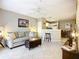 Inviting living room with a sofa, ottoman, tile flooring, open access to the kitchen and ceiling fan at 850 S Tamiami Trl # 207, Sarasota, FL 34236