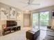 Well-lit living room with large sliding doors, tile flooring, comfortable sofa, and contemporary decor at 850 S Tamiami Trl # 207, Sarasota, FL 34236