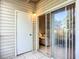 Enclosed tiled patio featuring sliding glass door, storage, and neutral siding at 850 S Tamiami Trl # 207, Sarasota, FL 34236