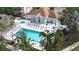 Aerial view of the community pool, hot tub, and lounge area, surrounded by lush landscaping and palm trees at 850 S Tamiami Trl # 207, Sarasota, FL 34236