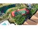 Overhead shot of community tennis court with pond and lush trees at 850 S Tamiami Trl # 207, Sarasota, FL 34236