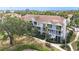 Three story condo building surrounded by mature trees, lush landscaping, and a scenic pond at 850 S Tamiami Trl # 730, Sarasota, FL 34236