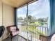 Relaxing screened balcony with seating offers serene views of the pond and lush landscaping at 850 S Tamiami Trl # 730, Sarasota, FL 34236