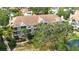 Three-story condo building with screened balconies, lush landscaping, and mature trees at 850 S Tamiami Trl # 730, Sarasota, FL 34236