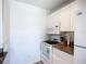 Galley-style kitchen with white cabinets, white appliances and granite countertops at 850 S Tamiami Trl # 730, Sarasota, FL 34236