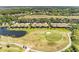 A bird's-eye view showcases golf course, a pond and a row of houses with palm trees at 9121 Stone Harbour Loop, Bradenton, FL 34212