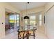 Cozy dining area with a glass-top table, floor tiles, and sliding glass doors leading to an enclosed patio at 9121 Stone Harbour Loop, Bradenton, FL 34212