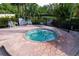 Outdoor hot tub surrounded by brick pavers, black metal fence, and lounge chairs at 9121 Stone Harbour Loop, Bradenton, FL 34212