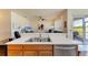 Kitchenette area with a stainless steel sink, wood cabinetry, and an open view into the living room at 9121 Stone Harbour Loop, Bradenton, FL 34212