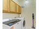 Bright laundry room with modern washer and dryer and wooden cabinets at 9121 Stone Harbour Loop, Bradenton, FL 34212