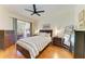 Well-lit main bedroom with a ceiling fan, dresser, and sliding glass doors at 9121 Stone Harbour Loop, Bradenton, FL 34212