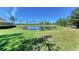Scenic backyard pond view with lush green grass, lily pads and palm trees under a clear blue sky at 9121 Stone Harbour Loop, Bradenton, FL 34212