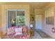 Inviting covered porch with a comfortable rattan couch, decorative pillows, and a view of the front yard at 9121 Stone Harbour Loop, Bradenton, FL 34212