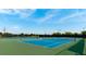 Bright blue tennis court surrounded by black fencing, perfect for an active lifestyle at 9121 Stone Harbour Loop, Bradenton, FL 34212