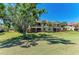 Beautiful backyard of a multi-story building with a manicured lawn and swaying palm trees under a clear blue sky at 9429 Discovery Ter # 102B, Bradenton, FL 34212