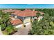 Expansive Mediterranean-style home with a red tile roof and attached two-car garage, surrounded by lush landscaping at 9429 Discovery Ter # 102B, Bradenton, FL 34212