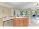 Kitchen island features stainless steel dishwasher, sink, seating, and wood cabinets at 9429 Discovery Ter # 102B, Bradenton, FL 34212
