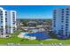 Aerial view features the community pools and grounds between high-rise condo buildings with beautiful ocean views at 1000 Longboat Club Rd # 604, Longboat Key, FL 34228