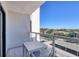 Balcony with table and chairs and views of tennis courts, parking, and residences at 1000 Longboat Club Rd # 604, Longboat Key, FL 34228