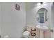 Chic powder room with pedestal sink, round mirror, toilet, and modern fixtures, offering a stylish space at 10510 Giddens Pl, Palmetto, FL 34221
