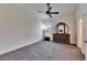 Cozy bedroom featuring a gray carpet, ceiling fan, window, and wooden dresser with decorative mirror at 10510 Giddens Pl, Palmetto, FL 34221
