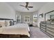 Bright bedroom with bay window, ceiling fan, and dresser, offering a comfortable and stylish retreat at 10510 Giddens Pl, Palmetto, FL 34221