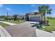Beautiful home featuring a paver driveway, manicured lawn, tropical landscaping, and a two-car garage at 10510 Giddens Pl, Palmetto, FL 34221