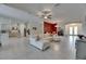 Open-concept living room boasts neutral tile flooring, a ceiling fan, and a comfortable white sectional sofa at 10510 Giddens Pl, Palmetto, FL 34221