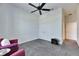 Cozy living room with gray carpet, a ceiling fan, two white doors, and two comfy purple armchairs at 10510 Giddens Pl, Palmetto, FL 34221