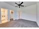 Spacious main bedroom featuring a walk-in closet, bathroom, ceiling fan, and light gray carpet at 10510 Giddens Pl, Palmetto, FL 34221