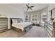 Spacious main bedroom boasts three bright windows, ceiling fan, and gray carpet, complete with stylish dressers at 10510 Giddens Pl, Palmetto, FL 34221