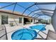 View of the pool and spa with an outdoor kitchen and dining under a screened in patio at 10510 Giddens Pl, Palmetto, FL 34221