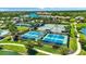 Aerial view of the community tennis courts surrounded by lakes and trees at 10510 Giddens Pl, Palmetto, FL 34221