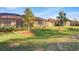 Expansive green backyard features lush landscaping and a screened-in lanai at 12091 Amica Loop, Venice, FL 34293