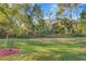 Lush backyard with plenty of trees and green grass surrounding the property at 12091 Amica Loop, Venice, FL 34293