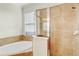 Bathroom boasts tub and walk-in shower with beige tile at 12091 Amica Loop, Venice, FL 34293