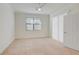 Well-lit bedroom with a ceiling fan, neutral carpet, and a large window at 12091 Amica Loop, Venice, FL 34293