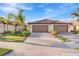 Lovely home with a three-car garage, paver driveway, and manicured landscaping, showcasing great curb appeal at 12091 Amica Loop, Venice, FL 34293