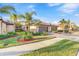 Beautiful home featuring a three-car garage, manicured landscaping, and a paver driveway enhancing its curb appeal at 12091 Amica Loop, Venice, FL 34293