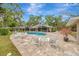 Large pool deck with comfortable lounge seating, lush greenery, and relaxing view of the backyard at 1240 Fox Creek Dr, Sarasota, FL 34240