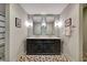 Stylish bathroom featuring double sinks, black cabinetry, and unique flooring with a shower to the left at 1240 Fox Creek Dr, Sarasota, FL 34240