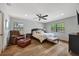 Spacious bedroom with wood floors, a ceiling fan, two windows, and a relaxing reading chair at 1240 Fox Creek Dr, Sarasota, FL 34240